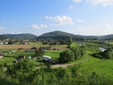 Na zdjęciu widoczne są bieszczadzka wieś, wzgórza rzeka i domy